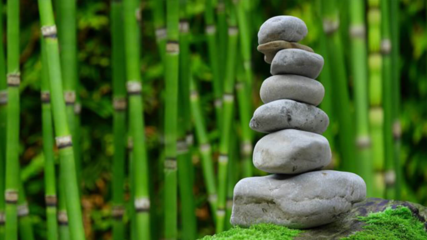 stones stacked elegantly next to bamboo