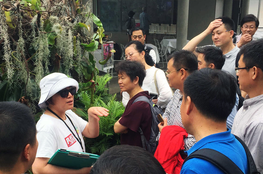 Cherie leading a group of people through a plant display