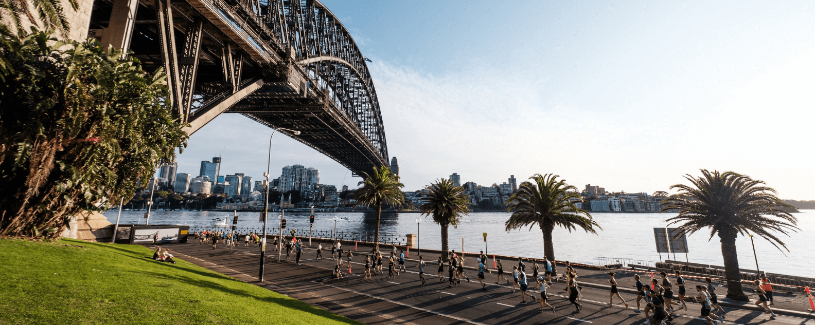 Racers jog on a path under the Sydney Harbour Bridge