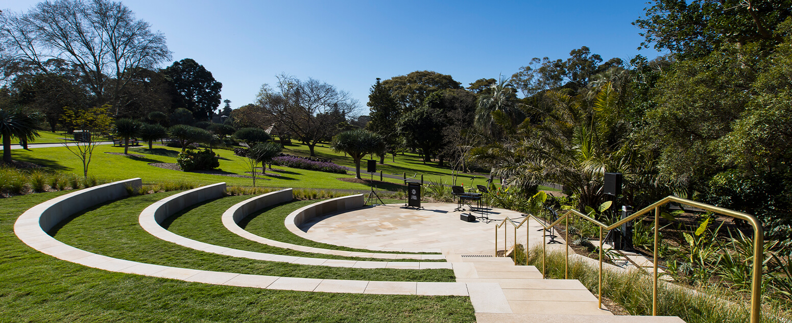 A round amphitheatre ready for performances in a lush Garden on a sunny day