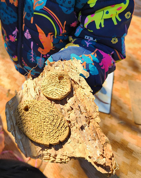 A child showing their finished clay pendants