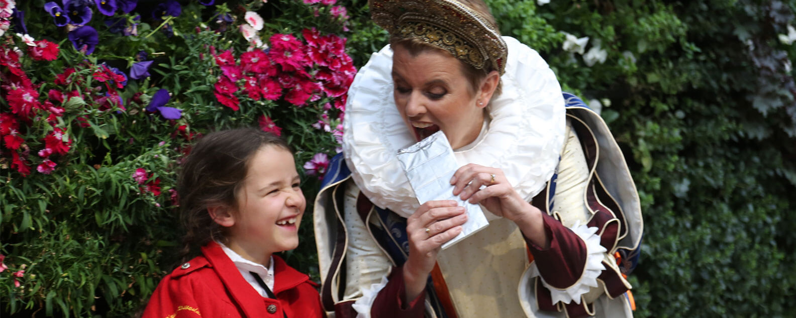 Girl laughing at woman pretending to eat a block of chocolate