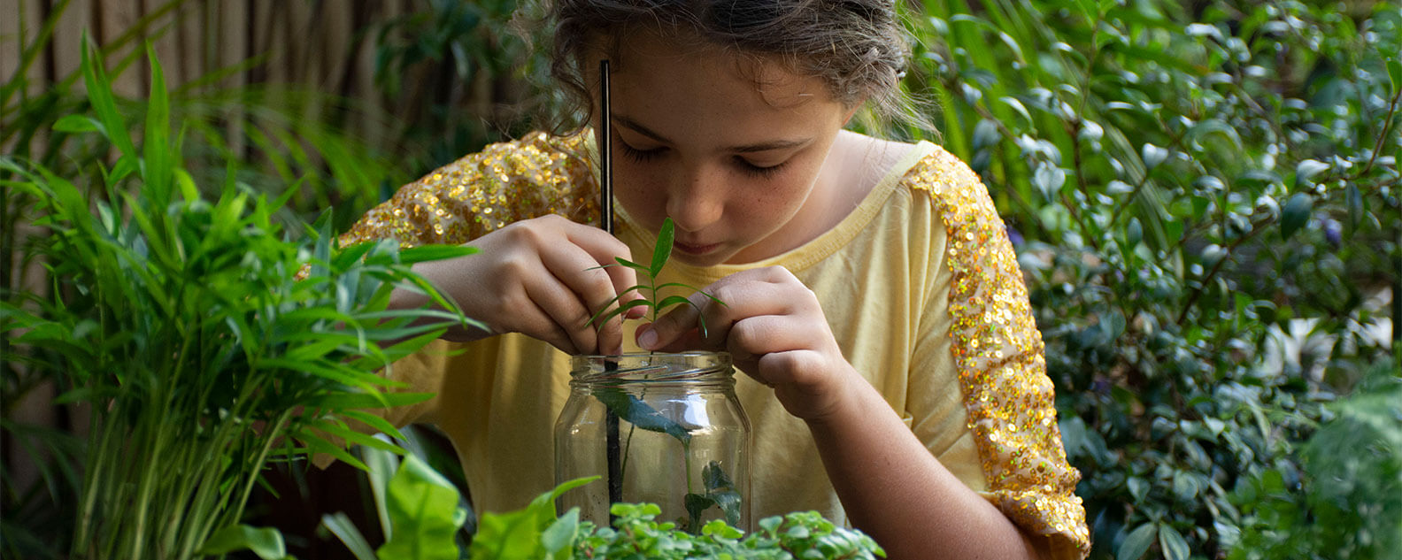 Girl placing plants into a jar