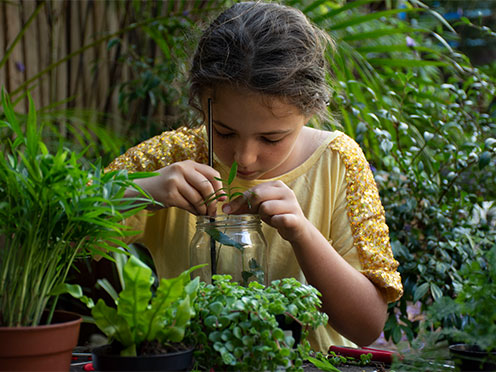 Girl placing plants into a jar