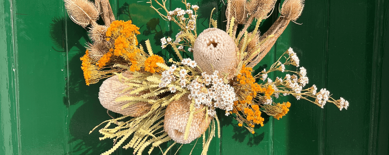 Dried wreath hanging on green front door