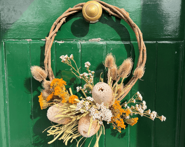 Dried wreath hanging on green front door