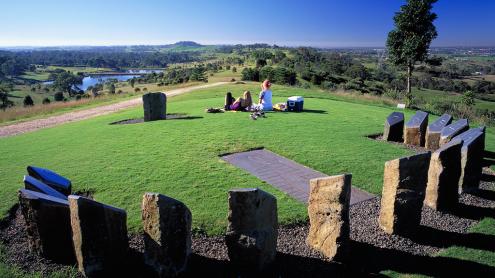 Two picnickers sitting on the lawn at the sundial