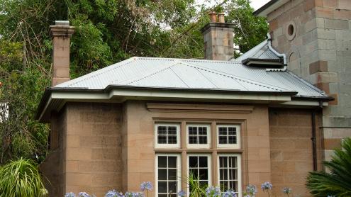 Sandstone cottage in shaded, leafy garden