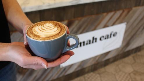 Woman holding coffee at Tomah Cafe