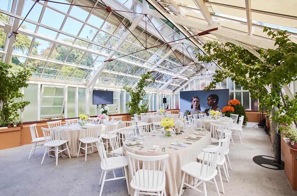 Interior of green house set up for an event with tables and chairs. Georg Jensen launch. Credit: Chloe Paul