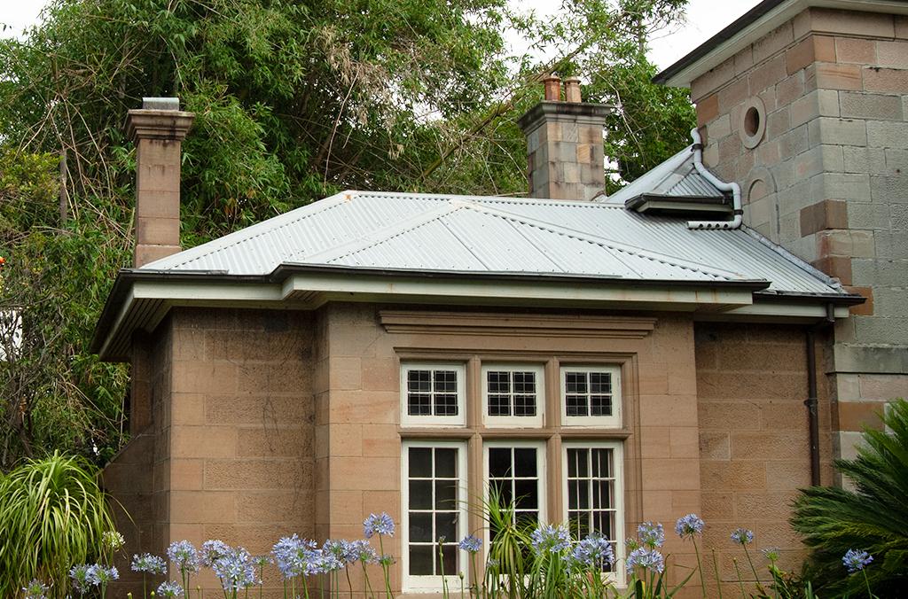 Sandstone cottage in shaded, leafy garden