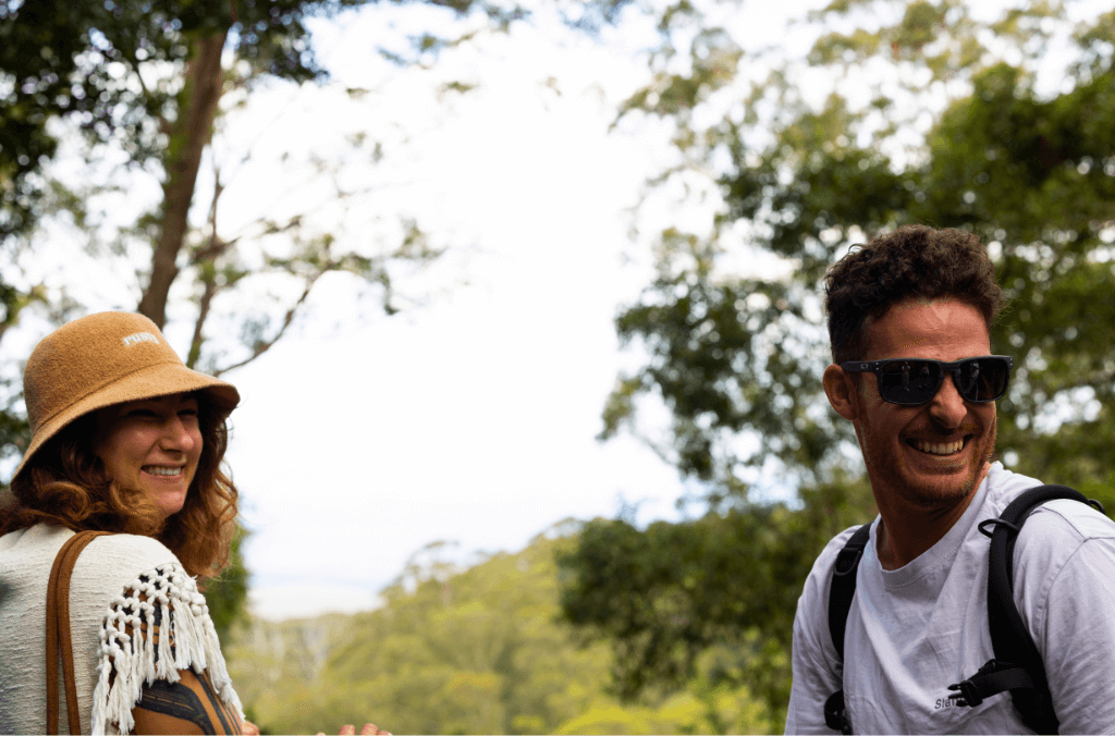 Two people looking away with a tree in the background